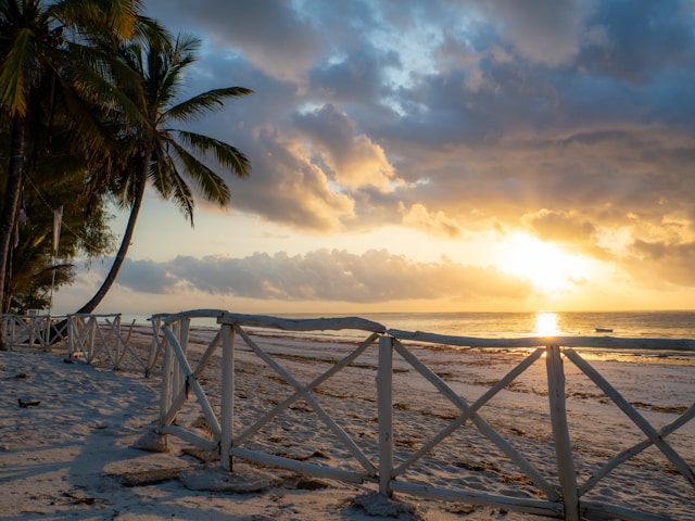 A sunrise over a white wooden fence at Diani Beach in Kenya